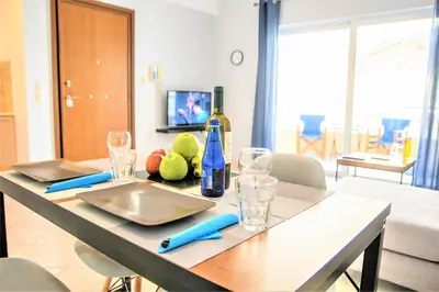 a table with a bottle of wine and glasses on it at Chania Central Flat in Chania Town