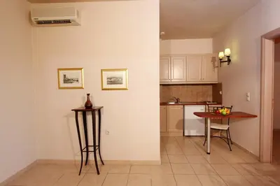 a kitchen with a table and a table and a counter at Lambrinos Suites in Plataniás