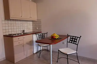 a kitchen with a table and two chairs and a sink at Lambrinos Suites in Plataniás