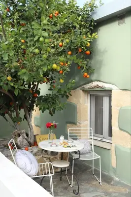 a table and chairs under an orange tree at Grandma's Nest in Kissamos