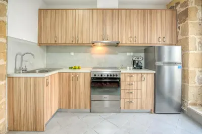 a kitchen with wooden cabinets and a stainless steel refrigerator at Grandma's Nest in Kissamos