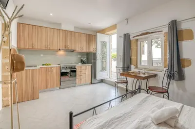 a kitchen with a bed and a table in a room at Grandma's Nest in Kissamos