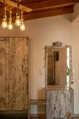 a mirror and a wooden door in a room with lights at Vitis Vinifera Tranditional Studio Apartment in Kissamos