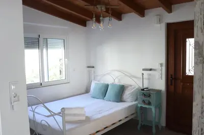 a white bedroom with a bed and a window at Vitis Vinifera Tranditional Studio Apartment in Kissamos