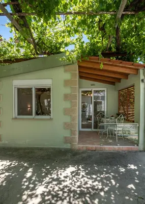 a house with a patio with a table and chairs at Vitis Vinifera Tranditional Studio Apartment in Kissamos