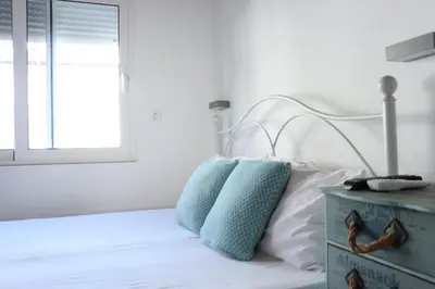 a bed with two pillows and a blue night stand at Vitis Vinifera Tranditional Studio Apartment in Kissamos