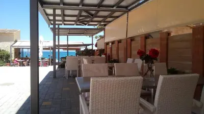 a table and chairs with flowers on a patio at Vaso Apartments in Plataniás