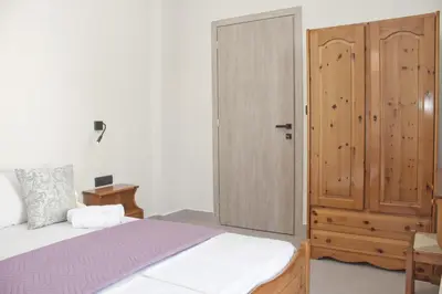 a bedroom with a bed and a wooden door at Vaso Apartments in Plataniás