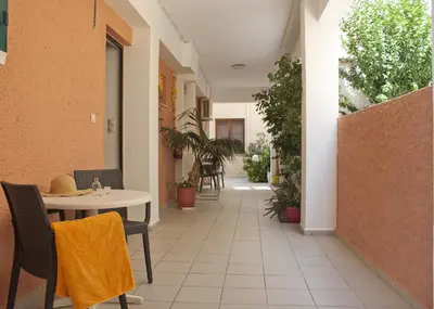 an empty corridor of a building with a table and chairs at Vaso Apartments in Plataniás