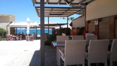 a table and chairs under an umbrella on a patio at Vaso Apartments in Plataniás
