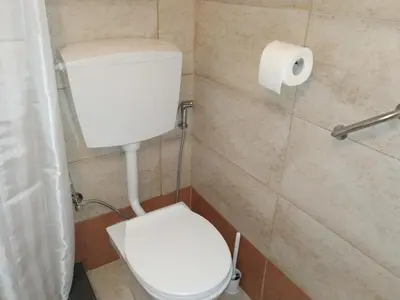 a bathroom with a toilet and a roll of toilet paper at Casa Patrikò Chania in Perivólia