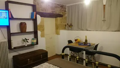 a room with a desk and a table with a television at Casa Patrikò Chania in Perivólia