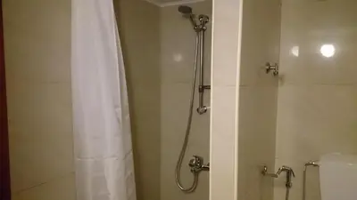 a shower with a white shower curtain in a bathroom at Casa Patrikò Chania in Perivólia