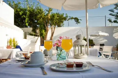 a table with a blue table cloth and glasses of orange juice at Balito in Kato Galatas