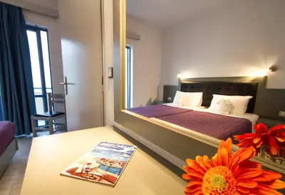 a bedroom with a bed with a mirror and a book on a table at Balito in Kato Galatas