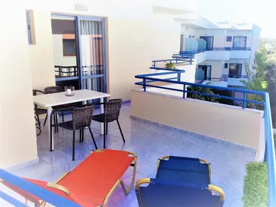 a balcony with chairs and tables and a table at Balito in Kato Galatas