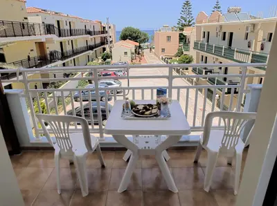 a table with a plate of food on a balcony at Despina Studios in Agia Marina Nea Kydonias