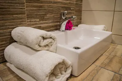 a bathroom with a sink and towels at Nireas Hotel in Kato Daratso
