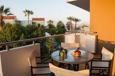 a table with a bowl of fruit on a balcony at Nireas Hotel in Kato Daratso