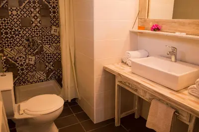 a bathroom with a sink and a toilet and a shower at Nireas Hotel in Kato Daratso