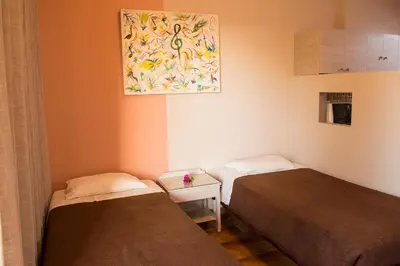 a room with two beds and a painting on the wall at Nireas Hotel in Kato Daratso