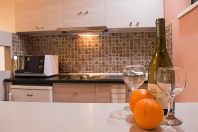 a kitchen with two glasses of wine and oranges on a counter at Nireas Hotel in Kato Daratso