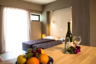 a table with a bottle of wine and fruit on it at Nireas Hotel in Kato Daratso