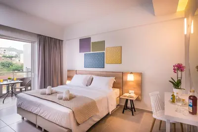 a hotel room with a bed and a balcony at IRINI STALOS Apartments in Stalos