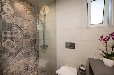 a bathroom with a shower with a toilet and a window at IRINI STALOS Apartments in Stalos