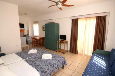 a bedroom with a bed and a couch in a room at Evropi Hotel in Plataniás