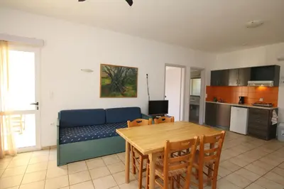a living room with a blue couch and a table at Evropi Hotel in Plataniás