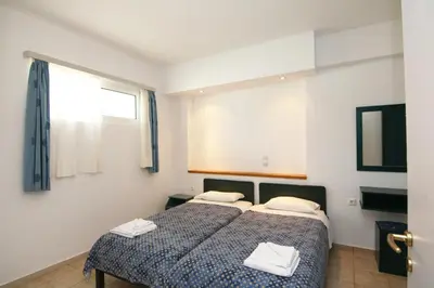 a bedroom with a bed with two towels on it at Evropi Hotel in Plataniás