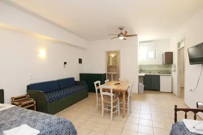 a living room with a couch and a table at Evropi Hotel in Plataniás