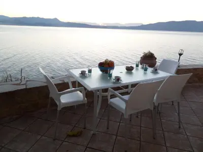 a white table and chairs with a view of the water at Endless Blue in Ravdhoúkha