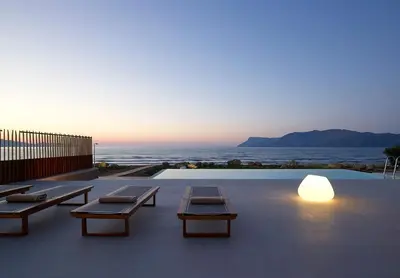 a patio with tables and a view of the ocean at Youphoria Beach Front Villas in Korfalónas