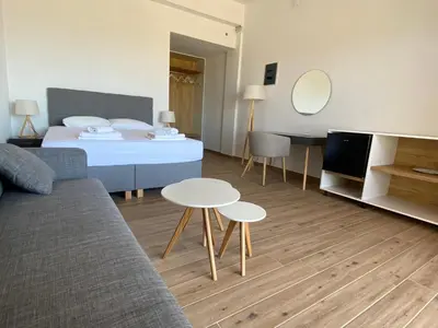 a bedroom with a bed and a table and a couch at Blue Sky in Frangokastello