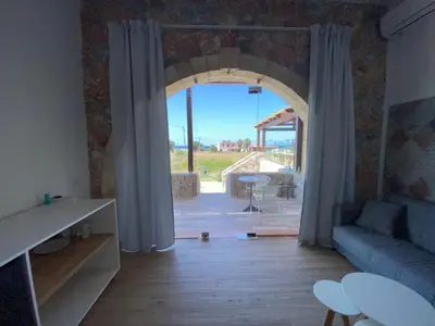 a living room with a large window and a couch at Blue Sky in Frangokastello
