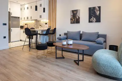 a living room with a blue couch and a table at Katerina Apartments in Kato Daratso