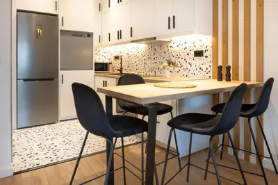 a kitchen with a wooden table and black chairs at Katerina Apartments in Kato Daratso