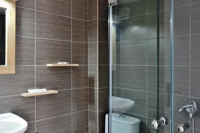 a bathroom with a shower and a toilet and a sink at Katerina Apartments in Kato Daratso