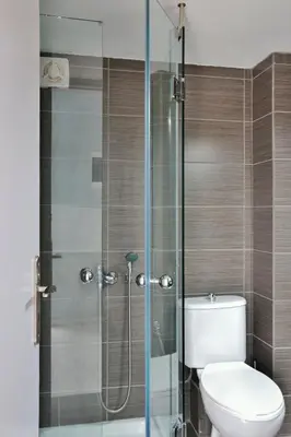 a bathroom with a toilet and a glass shower at Katerina Apartments in Kato Daratso
