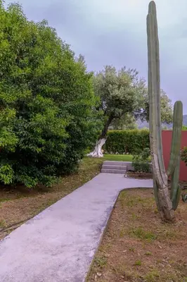 a sidewalk in a park with a cactus at Red Castle in Souda