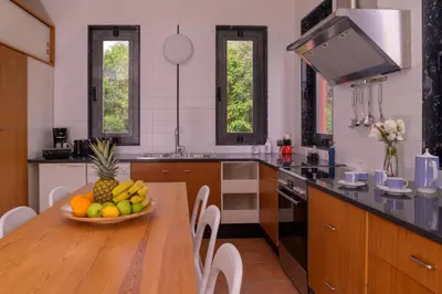 a kitchen with a table with a bowl of fruit on it at Red Castle in Souda