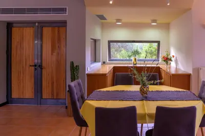 a dining room with a yellow table and chairs at Red Castle in Souda