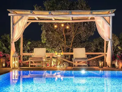 a gazebo and chairs next to a pool at Private Pool & Garden Villa for 6 in Pemónia