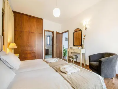 a bedroom with a large bed and a chair at Private Pool & Garden Villa for 6 in Pemónia