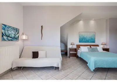 a hotel room with two beds and a couch at Andromia Studios & Apartments in Agia Marina Nea Kydonias