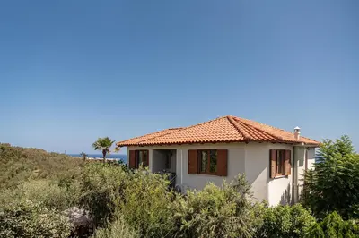 a small white house with a red roof at Andromia Studios & Apartments in Agia Marina Nea Kydonias