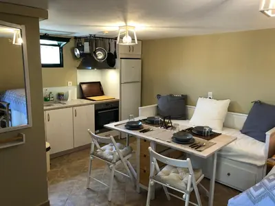 a small room with a kitchen and a table with chairs at Papaduke House in Kalyves