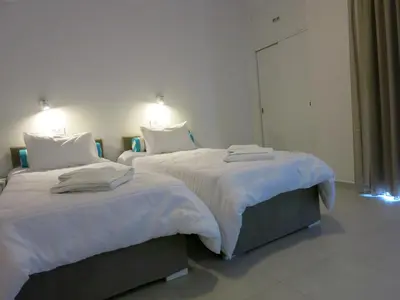 two beds in a hotel room with white sheets at Amaryllis in Plataniás